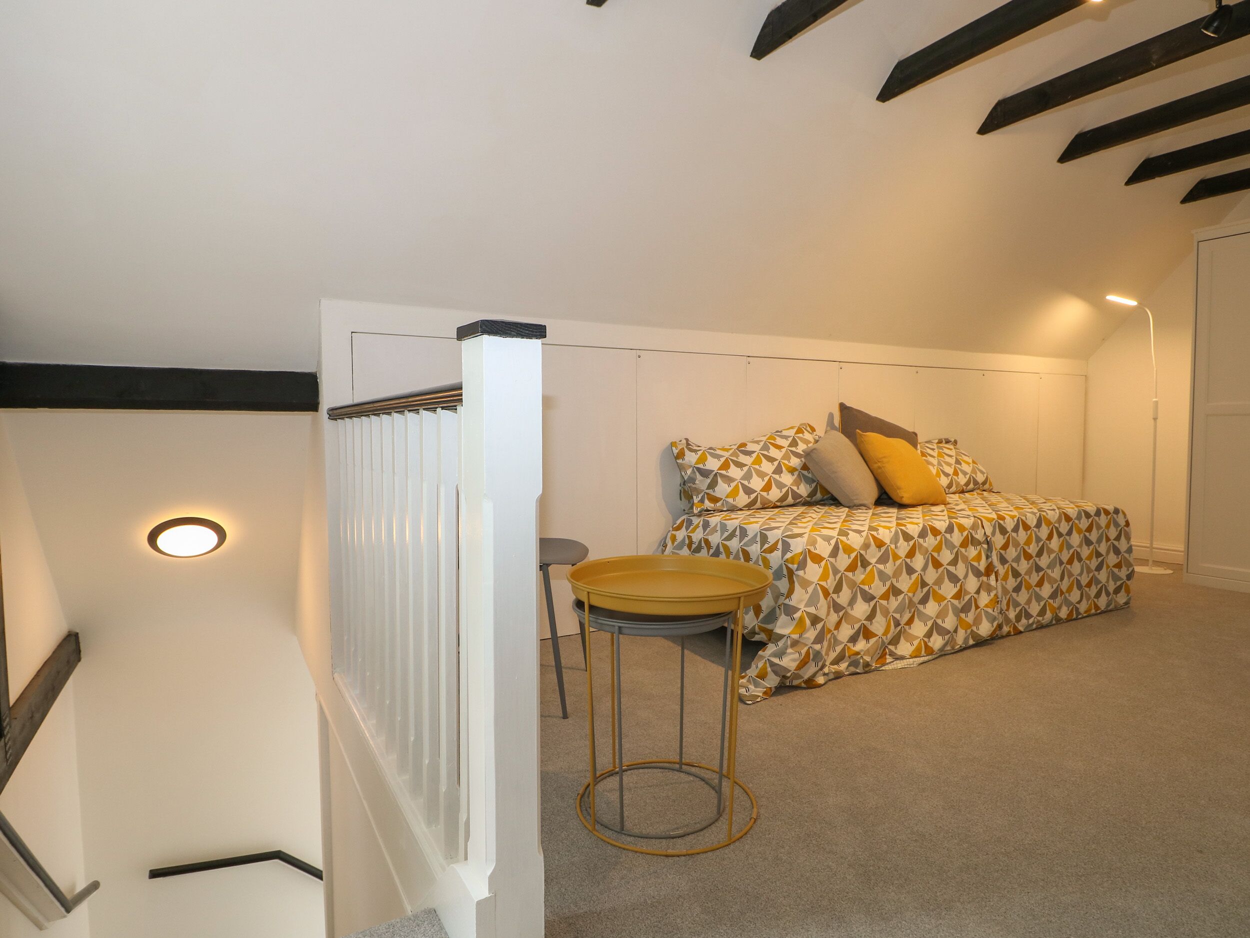 A bedroom with a bed, a small round table, and a radiator.