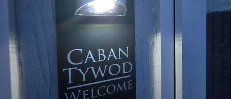 En skylt med texten ”CABAN TYWOD WELCOME” på en blå bakgrund.