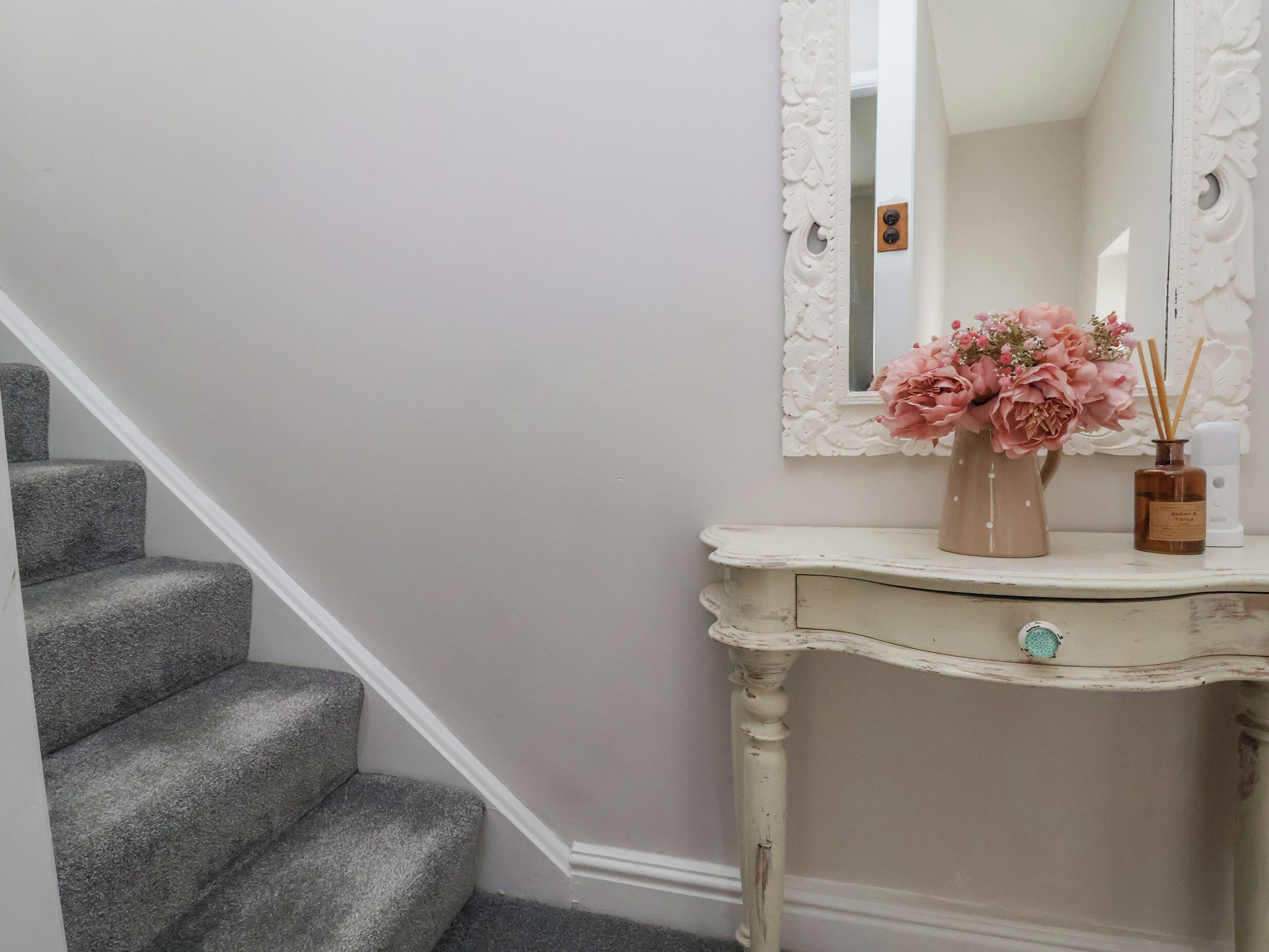 Eine Treppe mit grauen Teppichstufen, die zu einer weißen Wand führt.