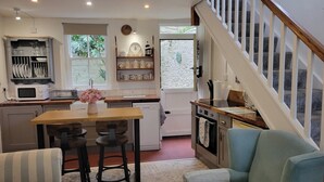 Una cocina con comedor, una escalera y vistas al exterior.