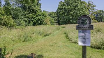 Un panneau indiquant l’emplacement de Farnborough Hall, avec un chemin qui traverse une zone herbeuse.