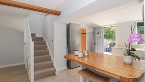 Una cocina moderna con una mesa de madera, horno empotrado y refrigerador.