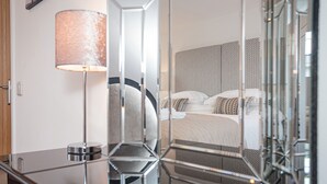 Moderni hotellihuone, jossa on suuri sänky, yöpöytä ja lamppu.