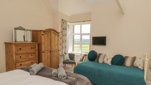 Une chambre avec deux lits, une armoire en bois, un bureau avec une chaise et une fenêtre donnant sur un beau paysage.