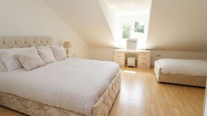 A bedroom with a large bed, a desk, and a window. - Bryn Awel (Denbigh)