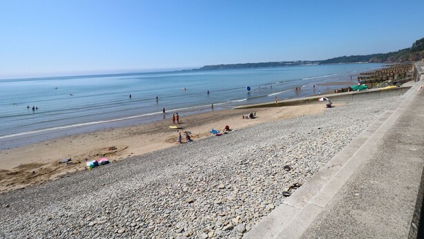 A beach with pebbles, a clear sky, and calm water. - Oakland Cottage (Narberth)