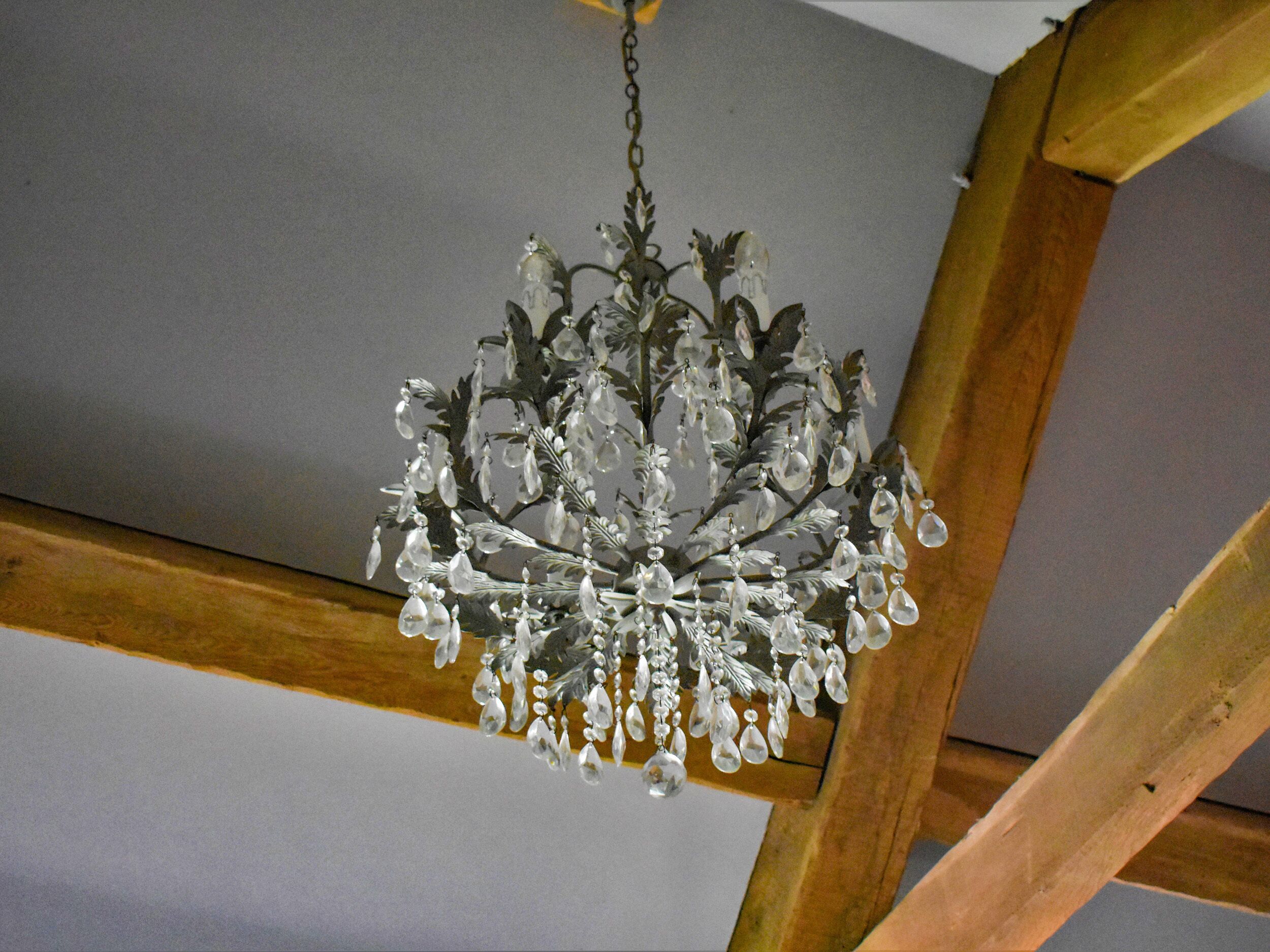A chandelier with multiple teardrop-shaped crystals hanging from a metal frame.