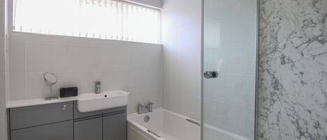 A modern bathroom with a toilet, sink, and bathtub.