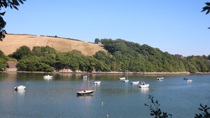 A calm lake with several boats anchored, surrounded by hills and dense trees. - Little Starboard (Kingsbridge)