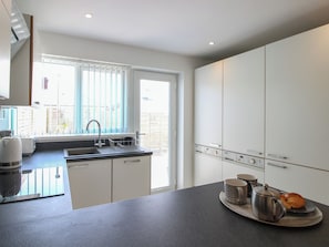 A modern kitchen with a sink, countertop, and cabinets.