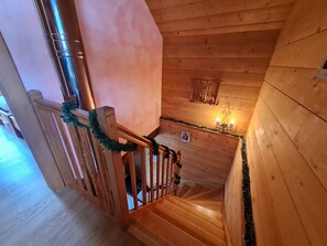 Una escalera de madera con barandilla, adornada con guirnaldas verdes.