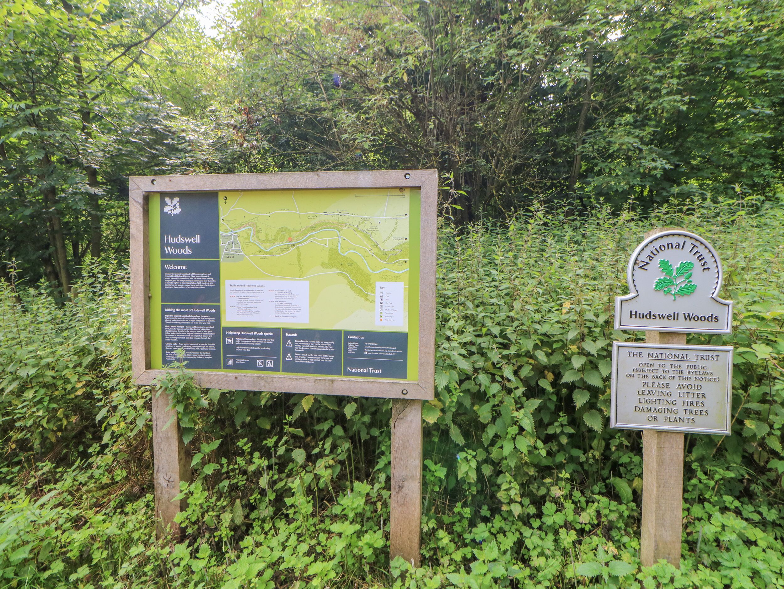 A signboard with information about Hudswell Woods, including a map and details about the area.