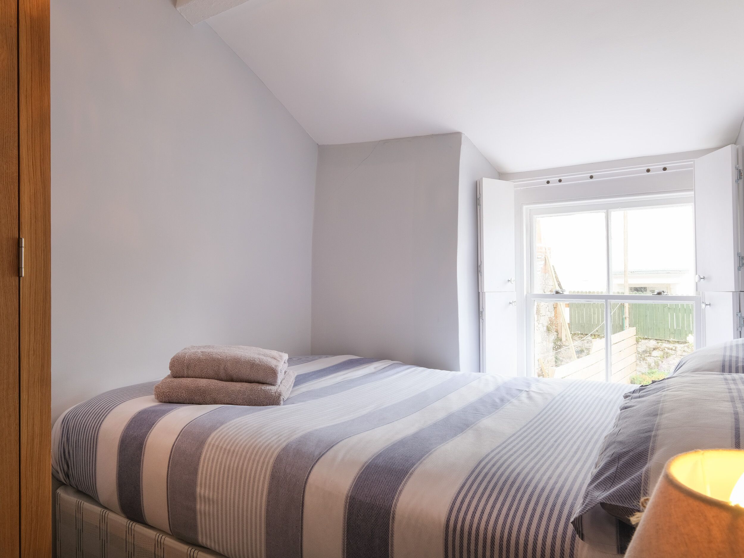 Une chambre à coucher avec un lit, une fenêtre et une porte.