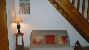 Un dormitorio con cama, lámpara, un cartel en la pared y una escalera.
