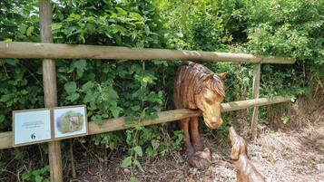 Une clôture en bois ornée d’une sculpture de cheval et d’un panneau.