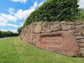 Eine Steinsäule mit dem Schild 'Lower Farm Holiday Cottages'.