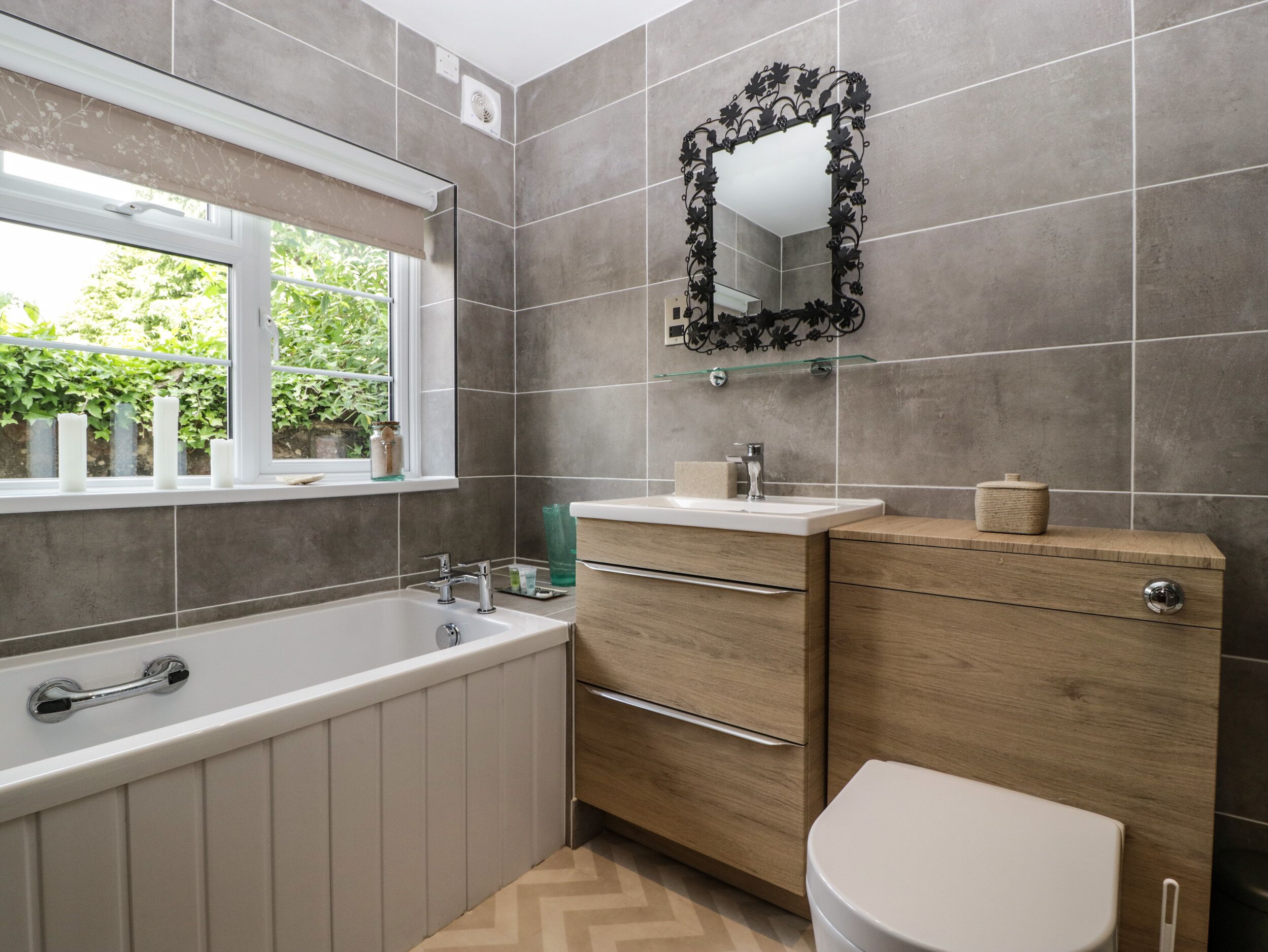 Un baño moderno con una bañera independiente, un tocador con espejo y un inodoro.