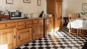 A kitchen with wooden cabinets, a microwave, toaster, and a checkered floor. - The Antlers (Coldstream)
