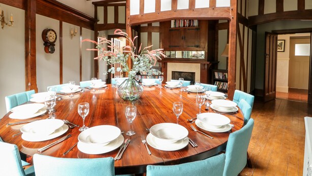 Comedor con una mesa de madera dispuesta para seis personas, rodeada de seis sillas.