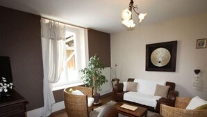 A cozy living room with a sofa, armchairs, a coffee table, and a potted plant. - Charming 5-Bedroom House with Large Garden, Terrace, and Authentic Decor in Le Val-d'Ajol (Le Val-d'Ajol)