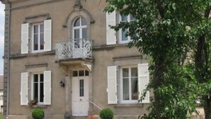 A two-story building with a balcony, white shutters, and a red-tiled roof. - Charming 5-Bedroom House with Large Garden, Terrace, and Authentic Decor in Le Val-d'Ajol (Le Val-d'Ajol)