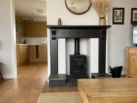 Una cocina moderna con armarios de madera, una chimenea negra y un espejo en la pared.