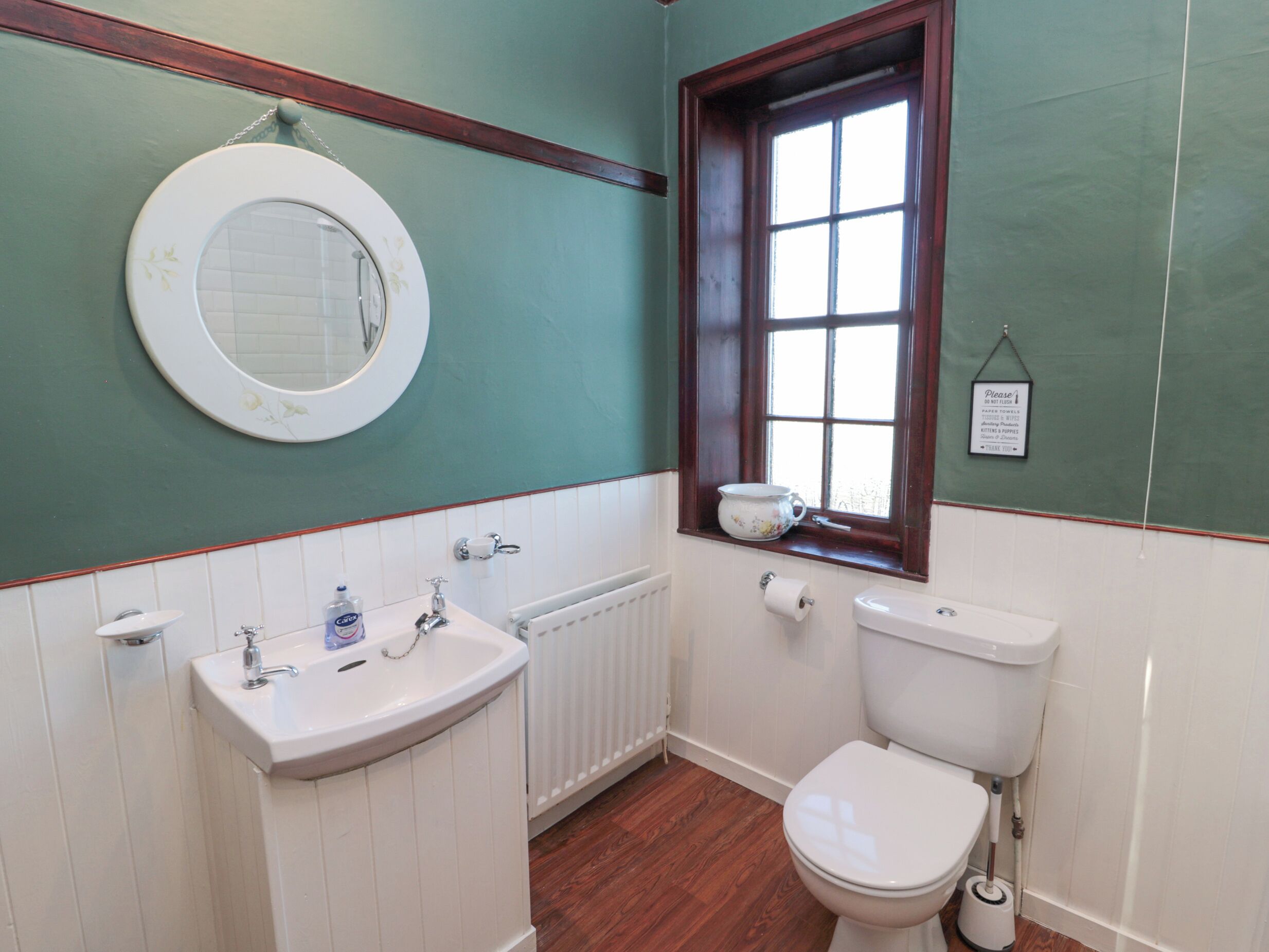 Ein Badezimmer mit Toilette, Waschbecken und einem Fenster mit Blick.