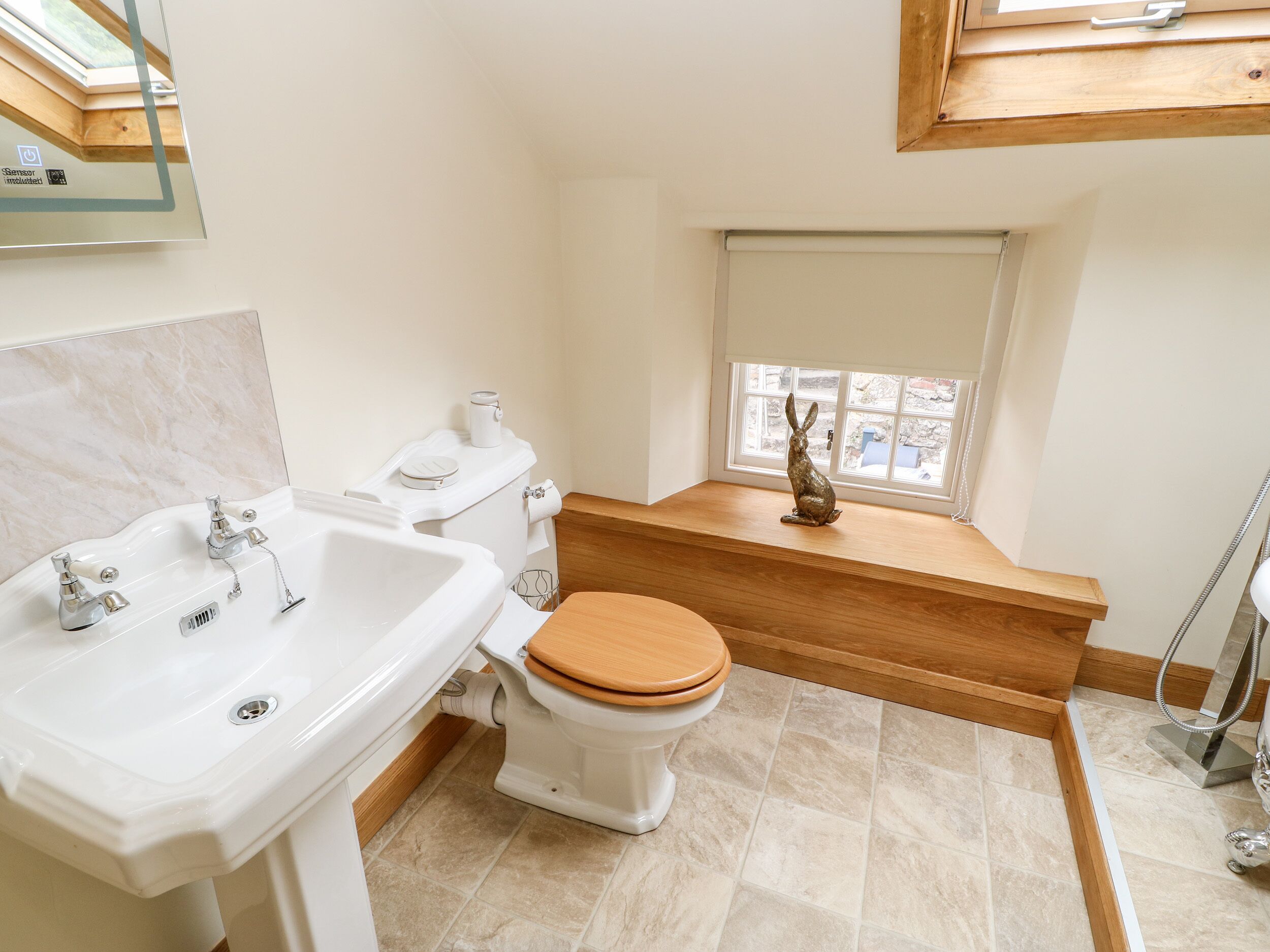 Ein Badezimmer mit Waschbecken, Toilette und Holz-Waschtisch.