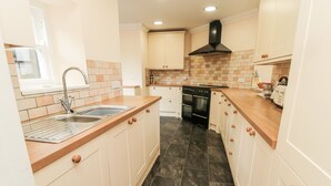 A kitchen with a sink, stove, and cabinets. - Jubilee House (Alnwick)