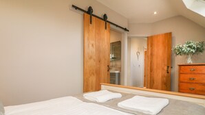 Un dormitorio con una cama grande, un armario de madera y un espejo.