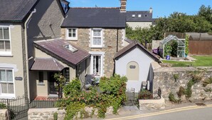 A stone house with a small garden, a conservatory, and a paved driveway. - Morawel Fach (Newport)
