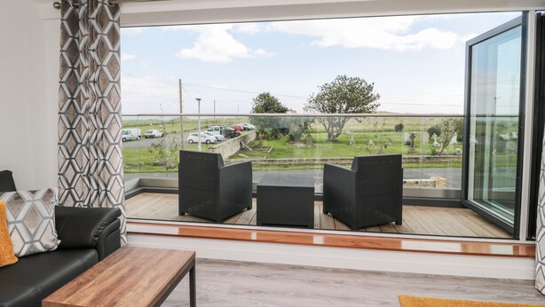 A balcony with a view of a cemetery and parked cars.