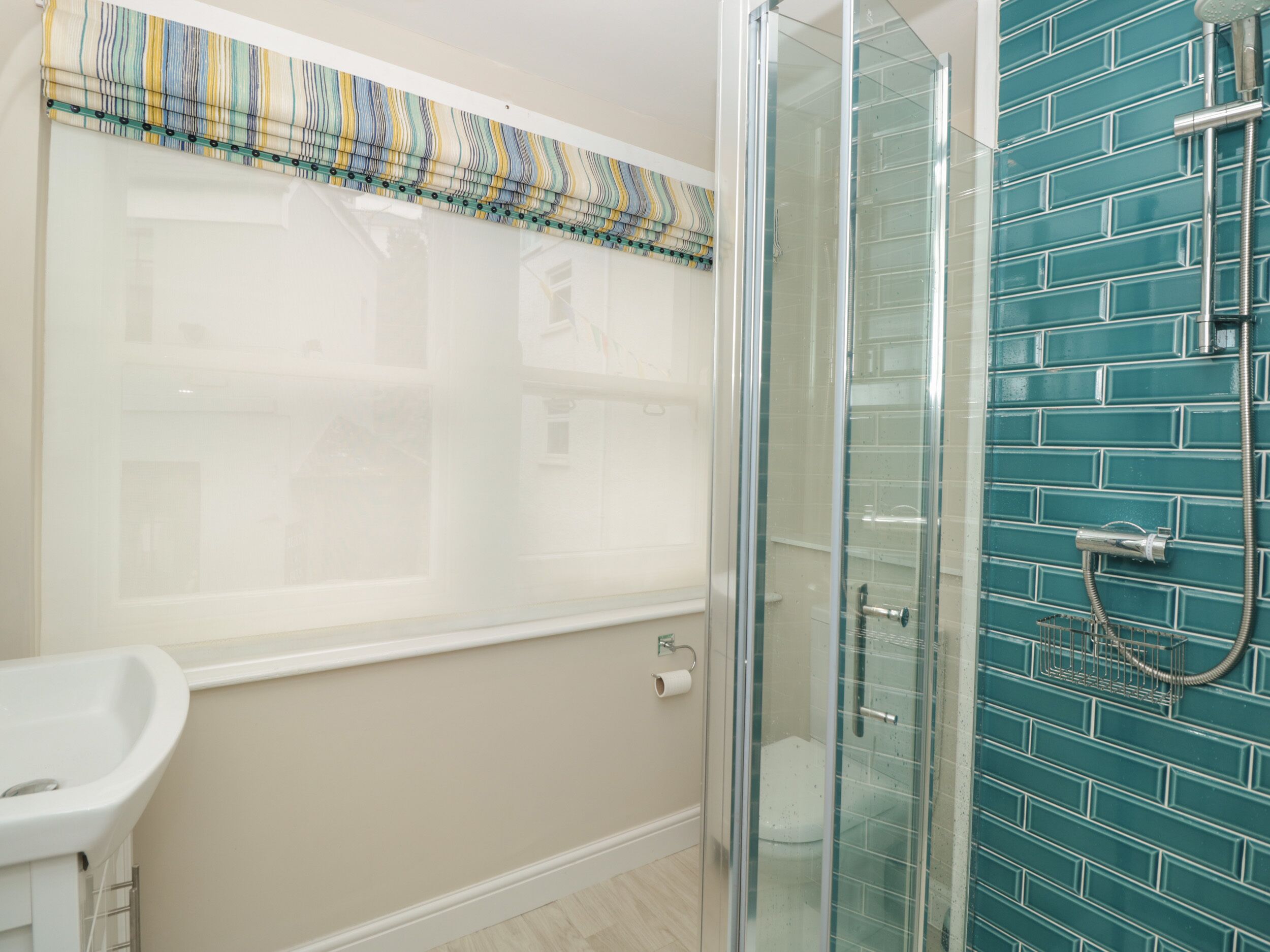 A bathroom with a glass shower enclosure, a bathtub, and a toilet.