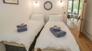 A double bed room with two pillows, a towel, and a framed deer picture on the wall. - The Barn (Redditch)