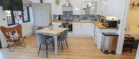 Una cocina moderna con comedor, televisor y ventana con vistas.