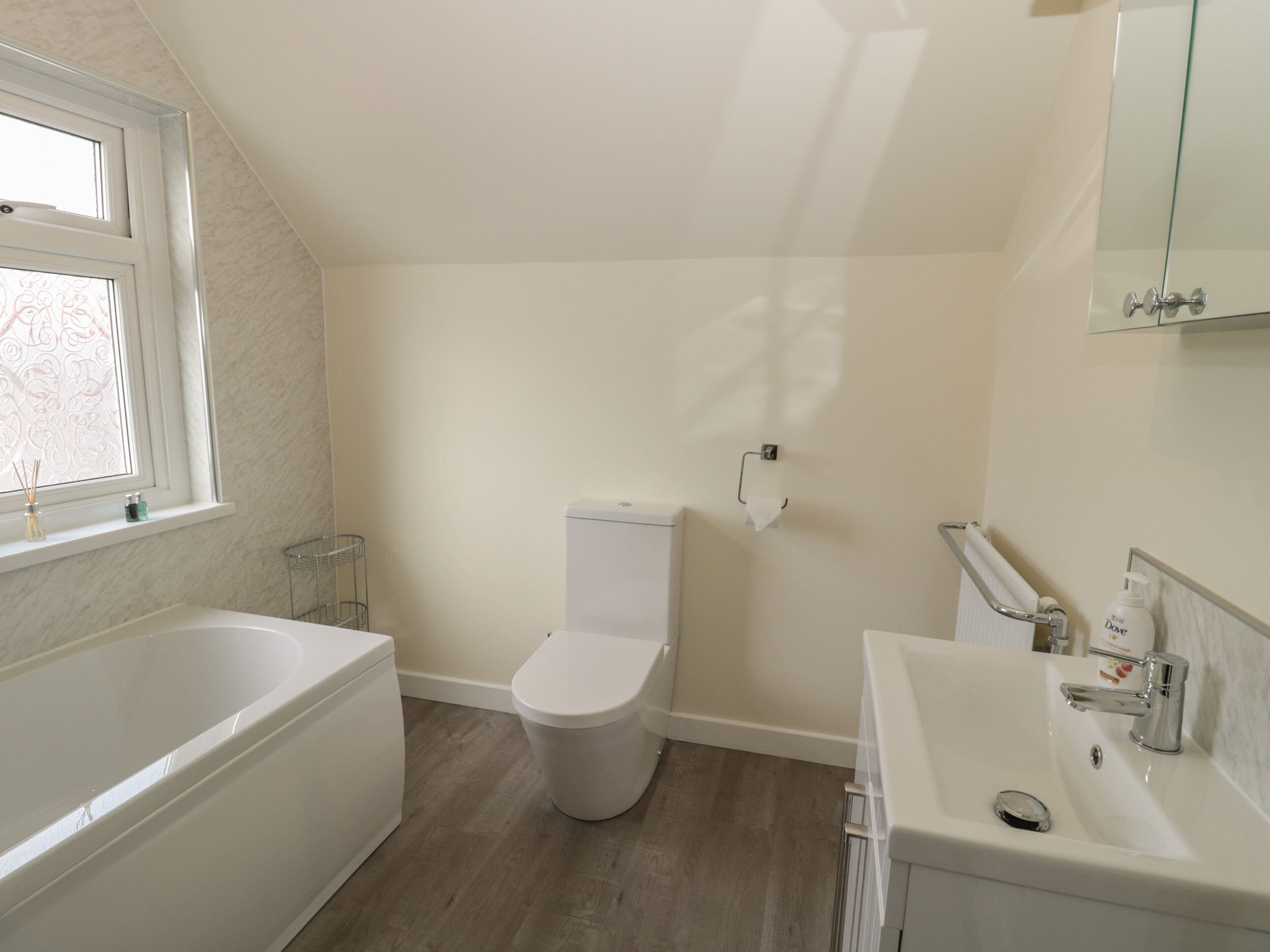 Een badkamer met een bad, toilet en wastafel.