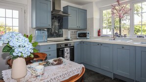 Una cocina con armarios azules, un microondas, un tostador y un lavabo.