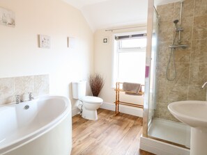 Un baño con bañera, inodoro y zona de ducha.