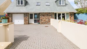 Ein zweistöckiges Haus mit Steinverkleidung, einer Garage und einem gepflasterten Auffahrt.