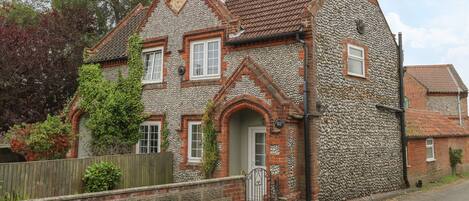 A traditional house with a stone facade, a tiled roof, and a brick chimney.