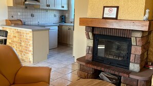 Eine moderne Küche mit Holzschränken, einer integrierten Kochinsel und einem Steinkamin.