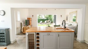 A modern kitchen with a central island, grey cabinets, and a view to the outdoors.