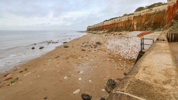 A beach with a rocky shoreline and a concrete barrier. - The Glass House (Hunstanton)