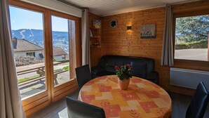 Una camera accogliente con un tavolo rotondo, un divano e vista sull'esterno.