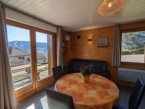 A cozy room with a round table, a sofa, and a view of the outside.