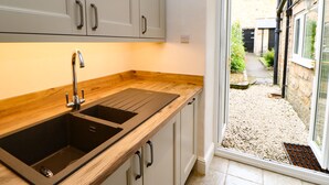 A modern kitchen with a wooden countertop and two sinks. - Stang View (Barnard Castle)