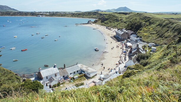 Un pueblo costero con playa, barcos y casas.