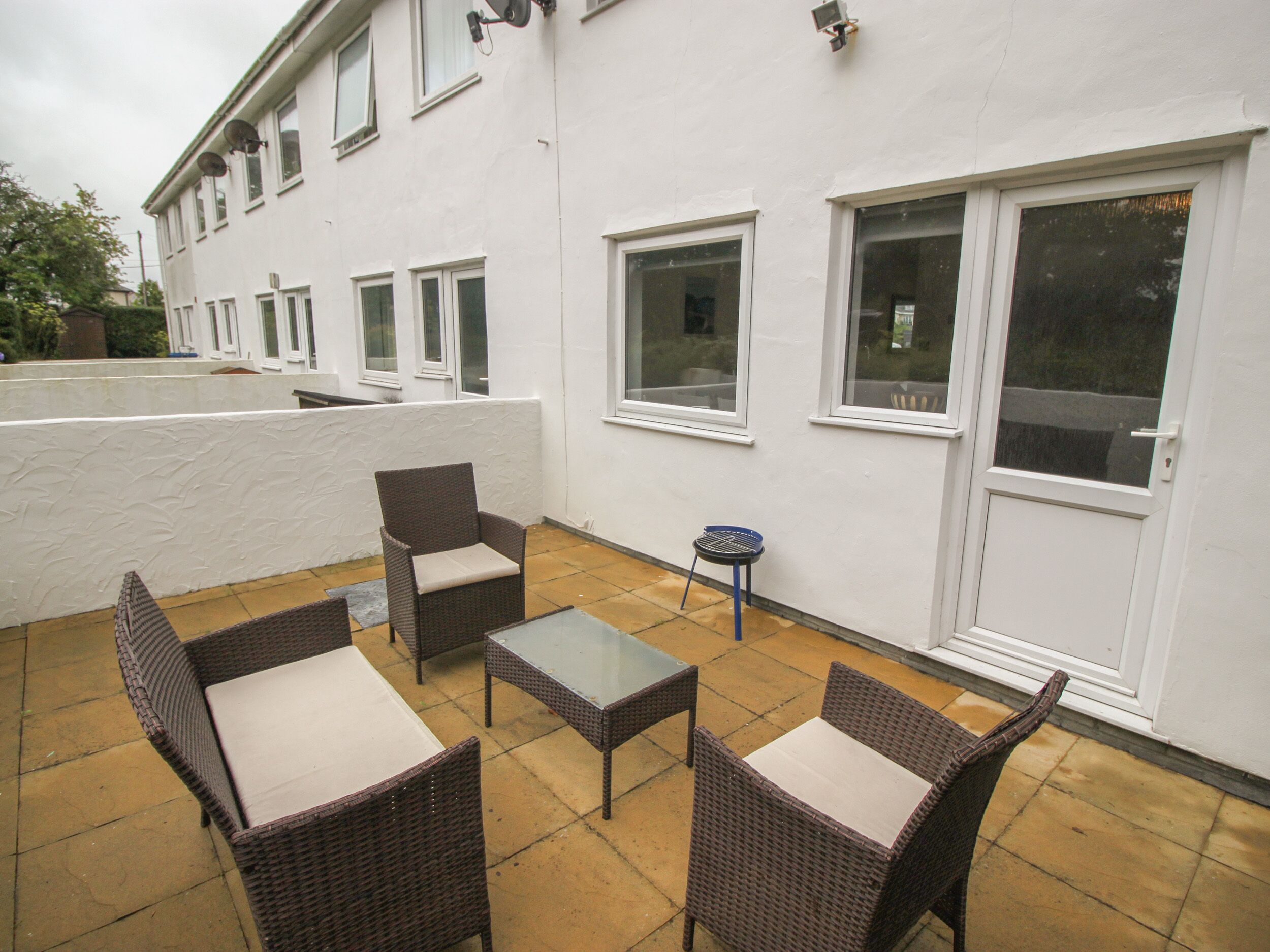 A patio with wicker furniture and a small table.