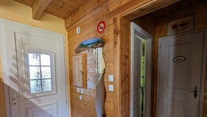 A wooden interior with a door, a window, and a wall-mounted sign. - Cozy Chalet by the Stream: Terrace, BBQ, Near Skiing & Cycling Paths, Pet Friendly (Vagney)