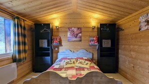 A cozy wooden cabin bedroom with a bed, shelves, and a window. - Cozy Chalet by the Stream: Terrace, BBQ, Near Skiing & Cycling Paths, Pet Friendly (Vagney)